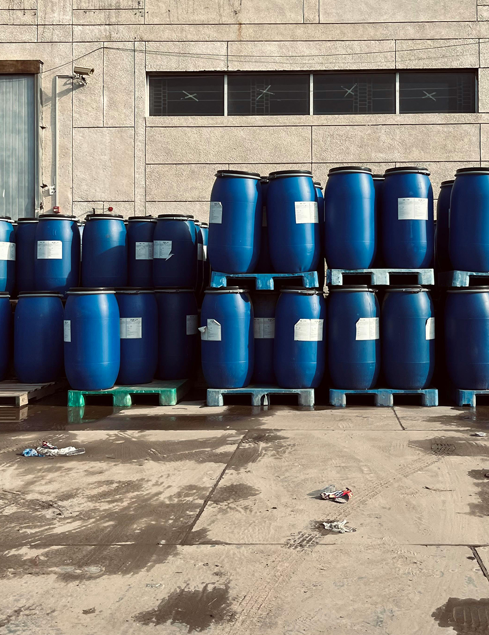 Cilindros de plástico azul almacenados sobre pallets en zona de acopio industrial de Caryma.